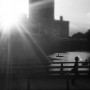 The sun sets over a pond with boaters in the heart of Akasaka