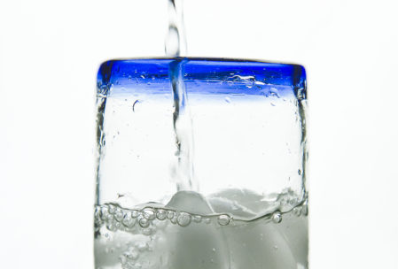 water pouring into a glass with a cobalt-blue rim