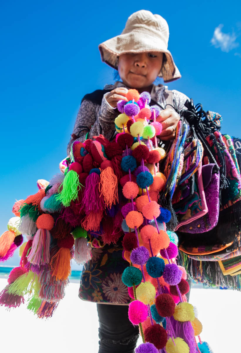 A woman selling colorful handicrafts on the beach in Puerto Morelos, Mexico. 