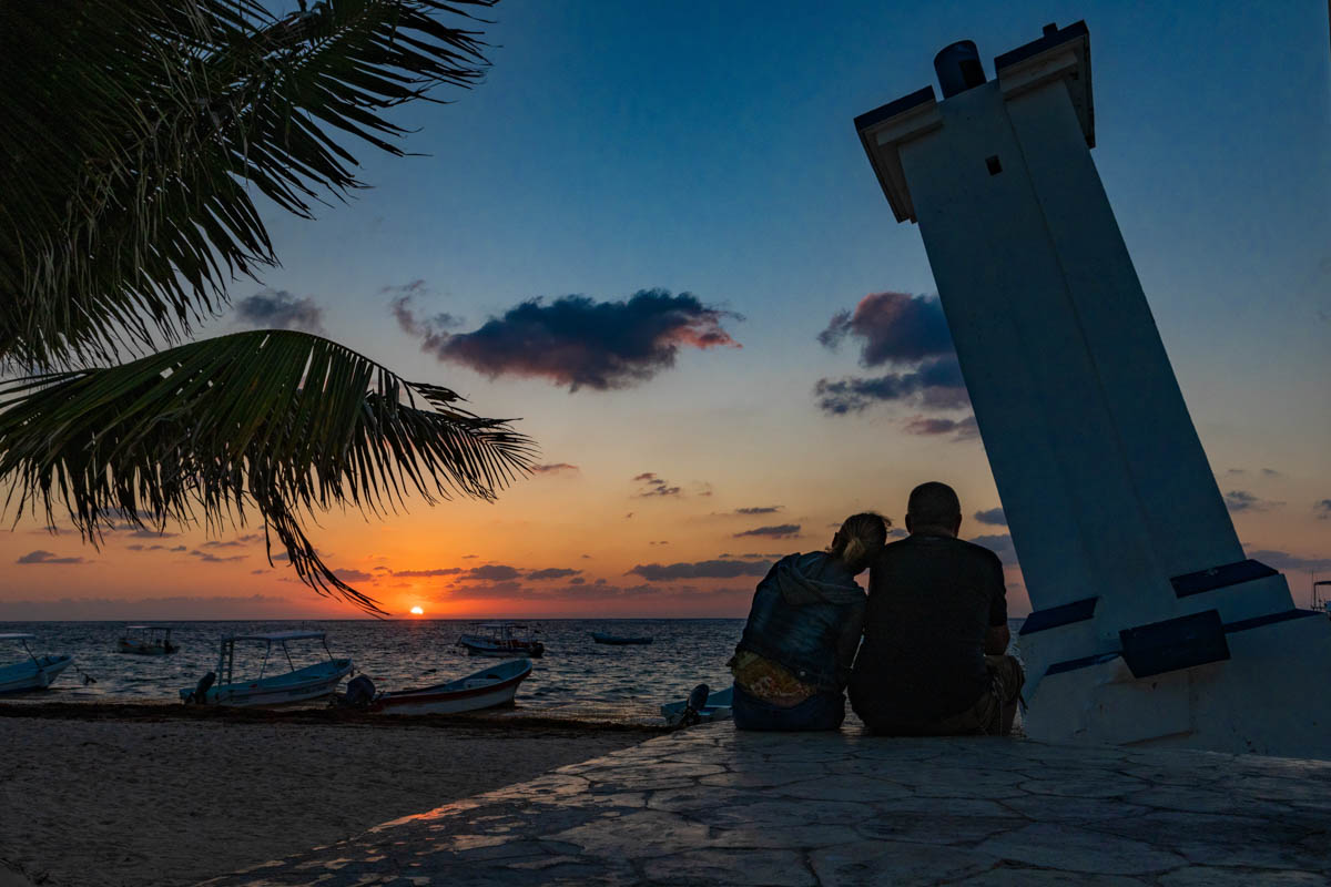 A couple watches the sunrise in Puerto Morelos.