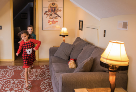 third floor loft of a christmas story house in cleveland. In this photo, two young kids run to the couch flanked by two leg lamps.